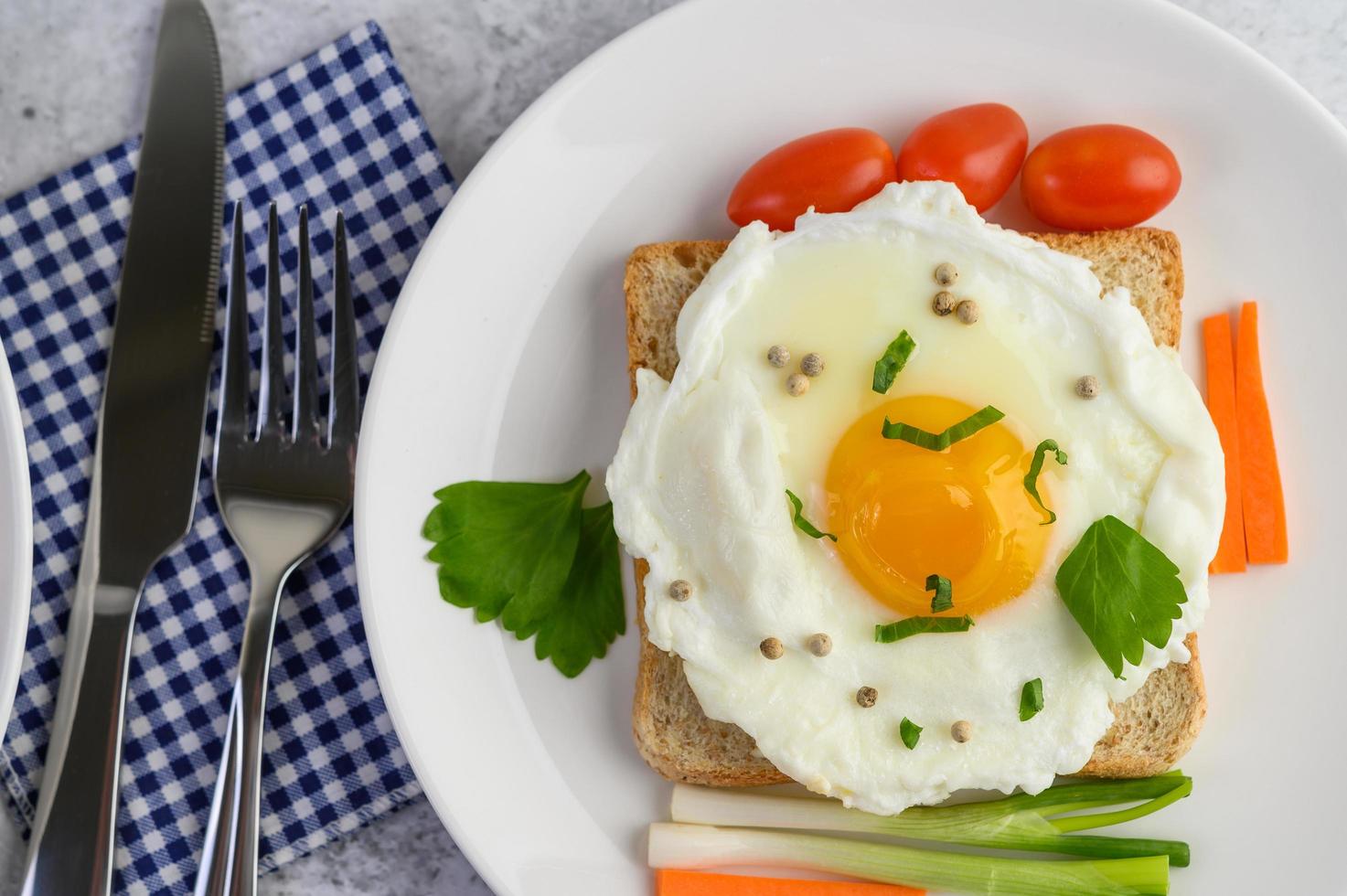 ein Spiegelei auf Toast mit Pfeffersamen, Karotten und Frühlingszwiebeln foto