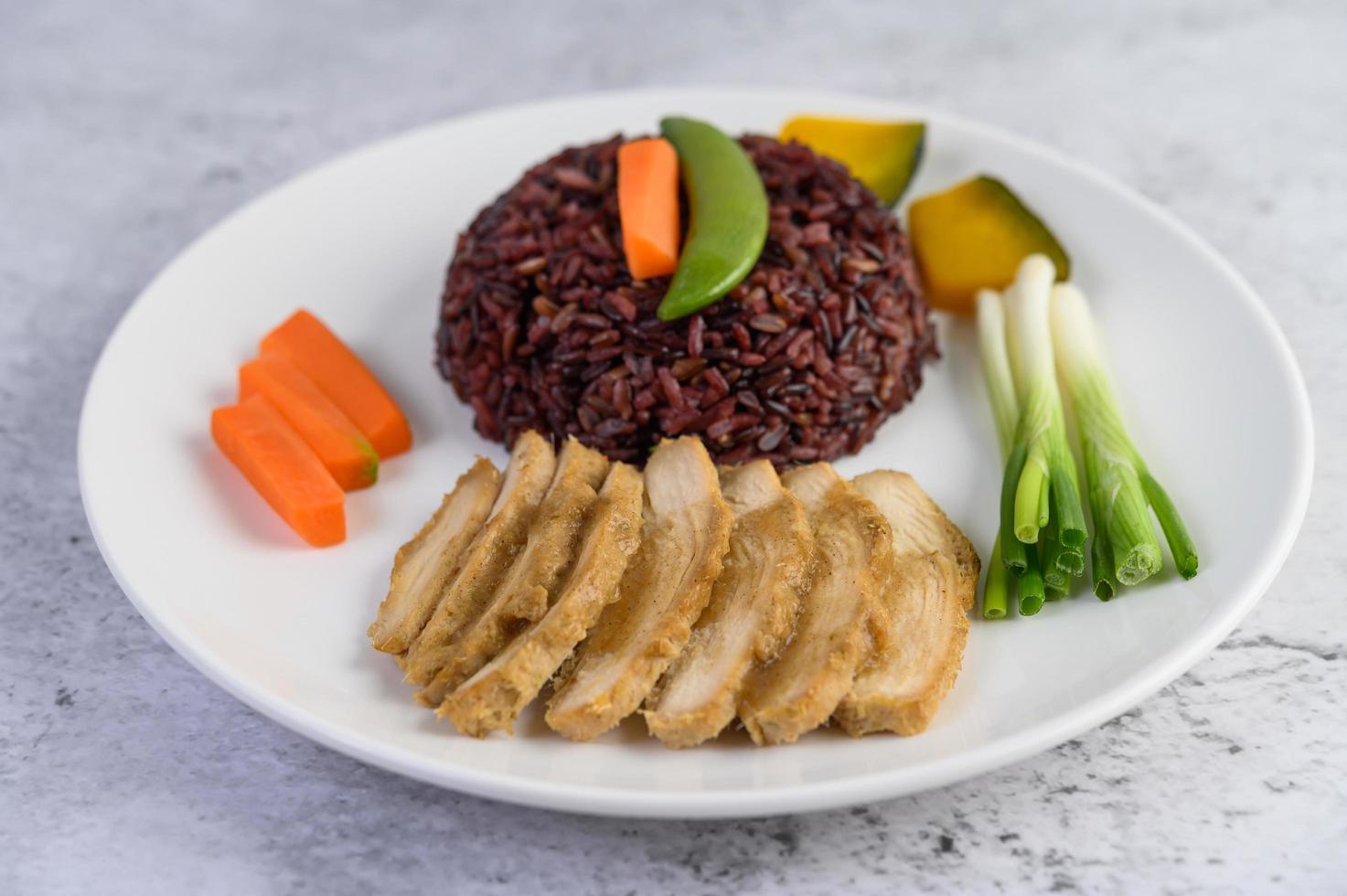 schwarzer Reis mit Kürbis, Erbsen, Karotten, Babymais und gedämpfter Hühnerbrust foto