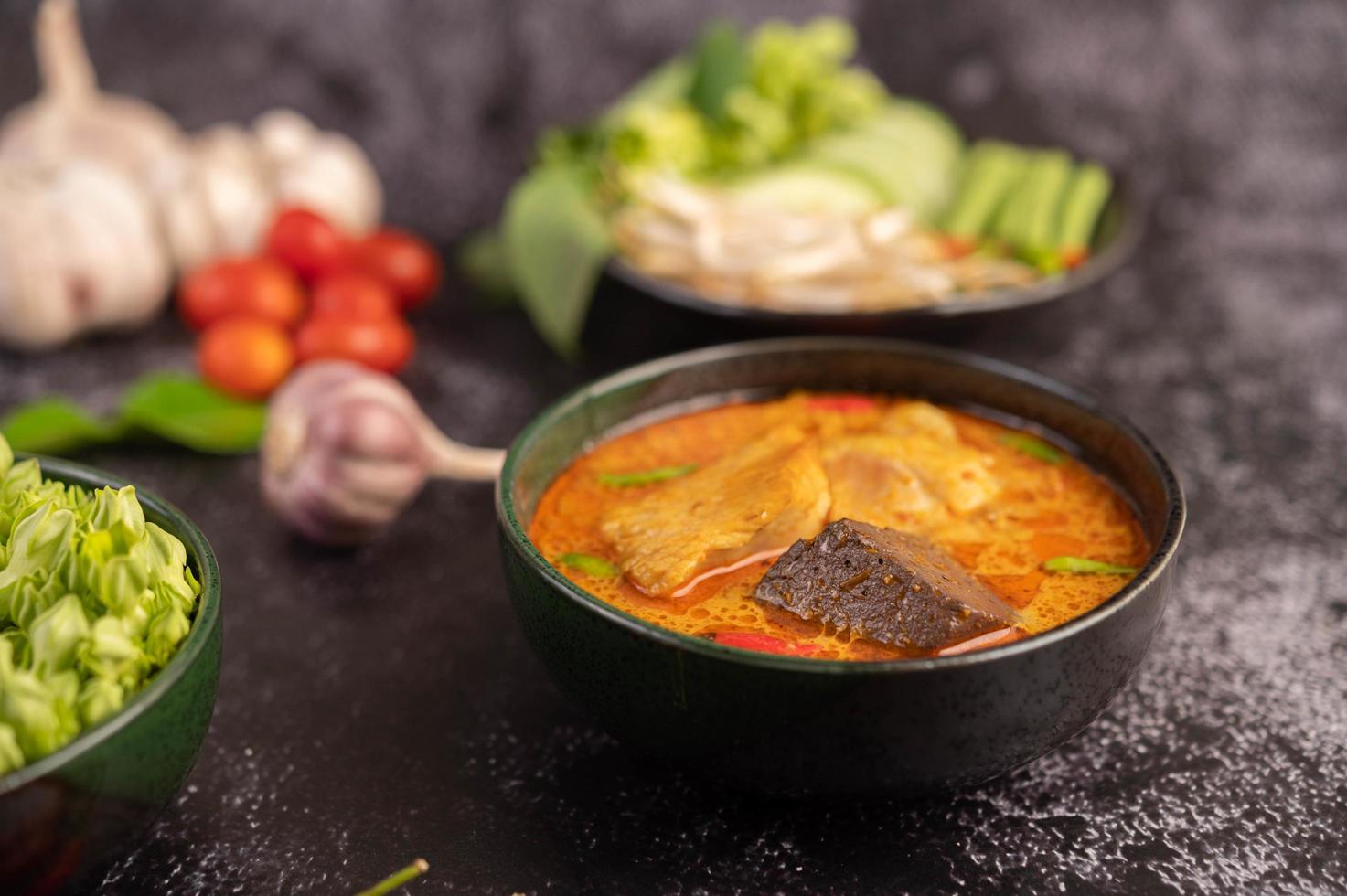 Hühnercurry in einer schwarzen Tasse mit Reisnudeln foto