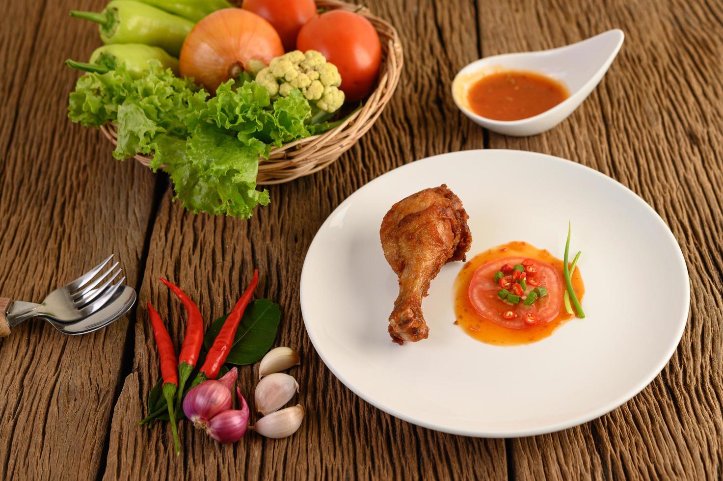 gebratene Hähnchenschenkel mit Sauce und Gemüse foto