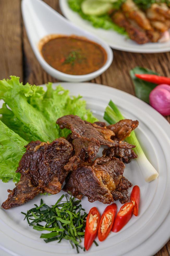 Rindfleisch gebratenes thailändisches Essen mit Frühlingszwiebeln, Limette, Chili und Salat foto
