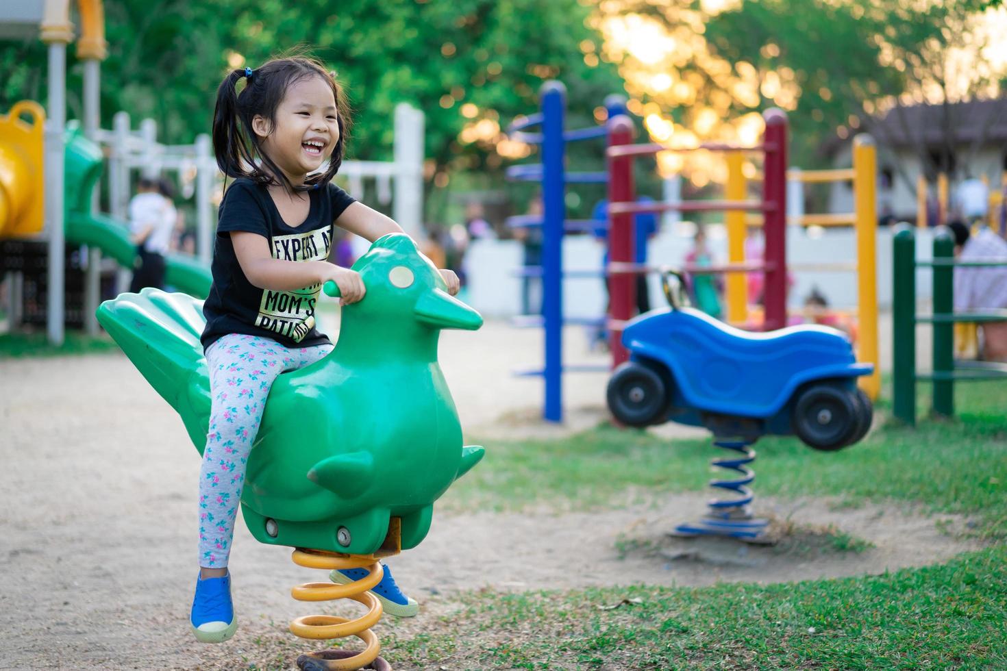 asiatisches kleines Mädchen spielt gerne auf einem Kinderspielplatz foto