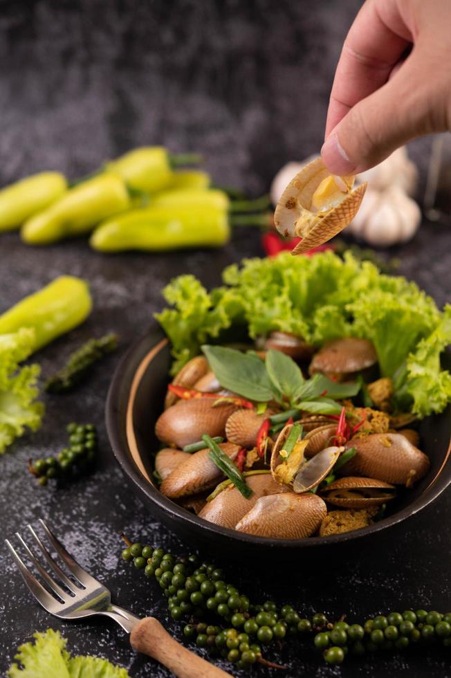 Muscheln mit Currypulver auf einem schwarzen Teller gebraten foto