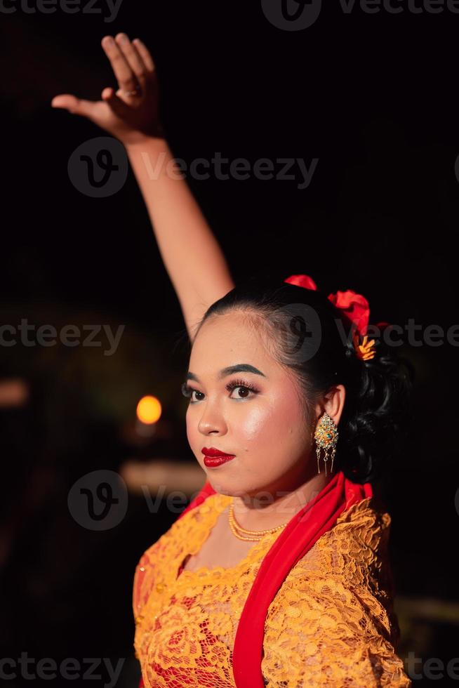 das schöne Nahgesicht einer javanischen Frau mit Make-up bei einer traditionellen Tanzaufführung, während sie ein gelbes Kostüm trägt foto