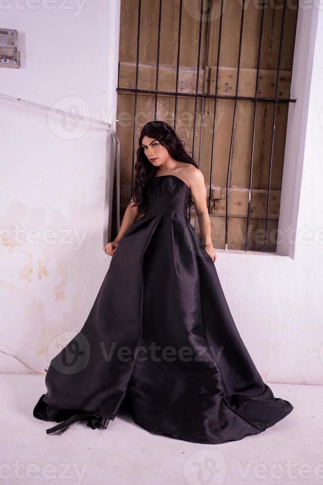 asiatische frau, die im holzfenster steht, während sie ein schwarzes kleid trägt foto