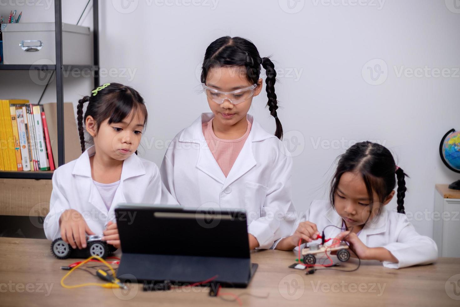 asiatische schüler lernen zu hause, indem sie roboterautos und elektronische platinenkabel in stamm, dampf, mathematik, ingenieurwesen, wissenschaft, technologie, computercode in robotik für kinderkonzepte codieren. foto
