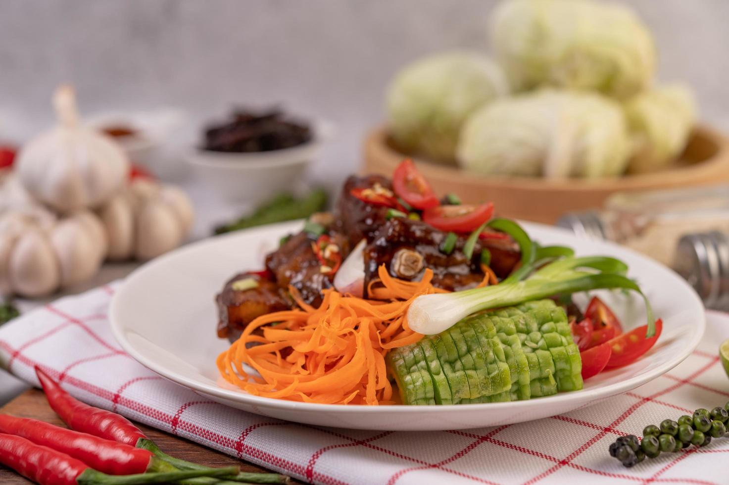 süßes Schweinefleisch mit gehackten Frühlingszwiebeln, Chili, Limette, Kürbis, Tomate und Knoblauch foto