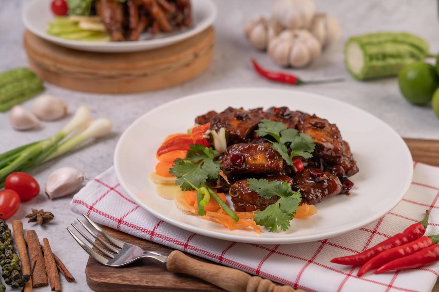 süßes Schweinefleisch mit Paprika, Frühlingszwiebeln, Karotten und Tomaten foto