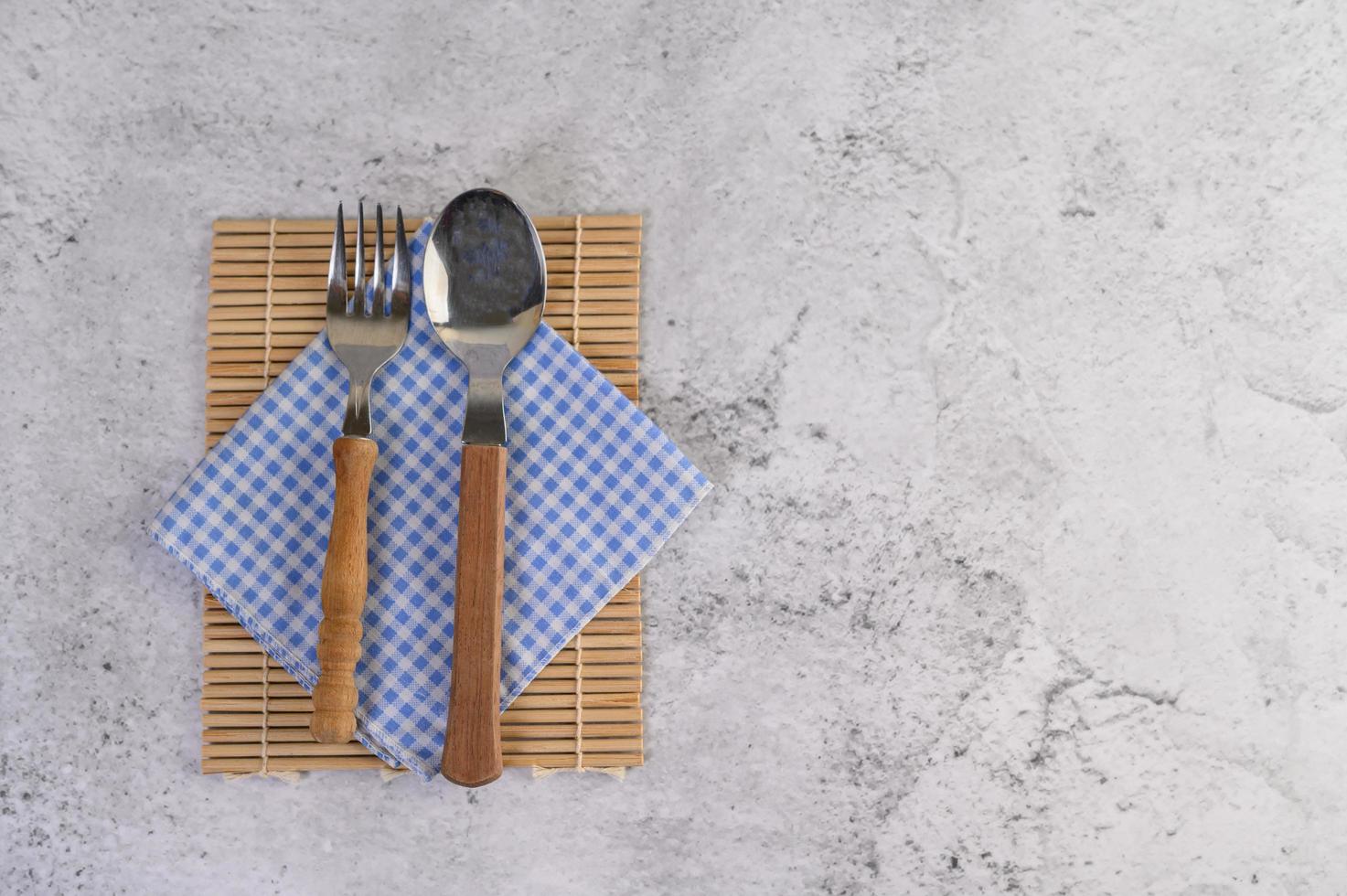 Löffel und Gabel auf blauen und weißen Taschentüchern foto