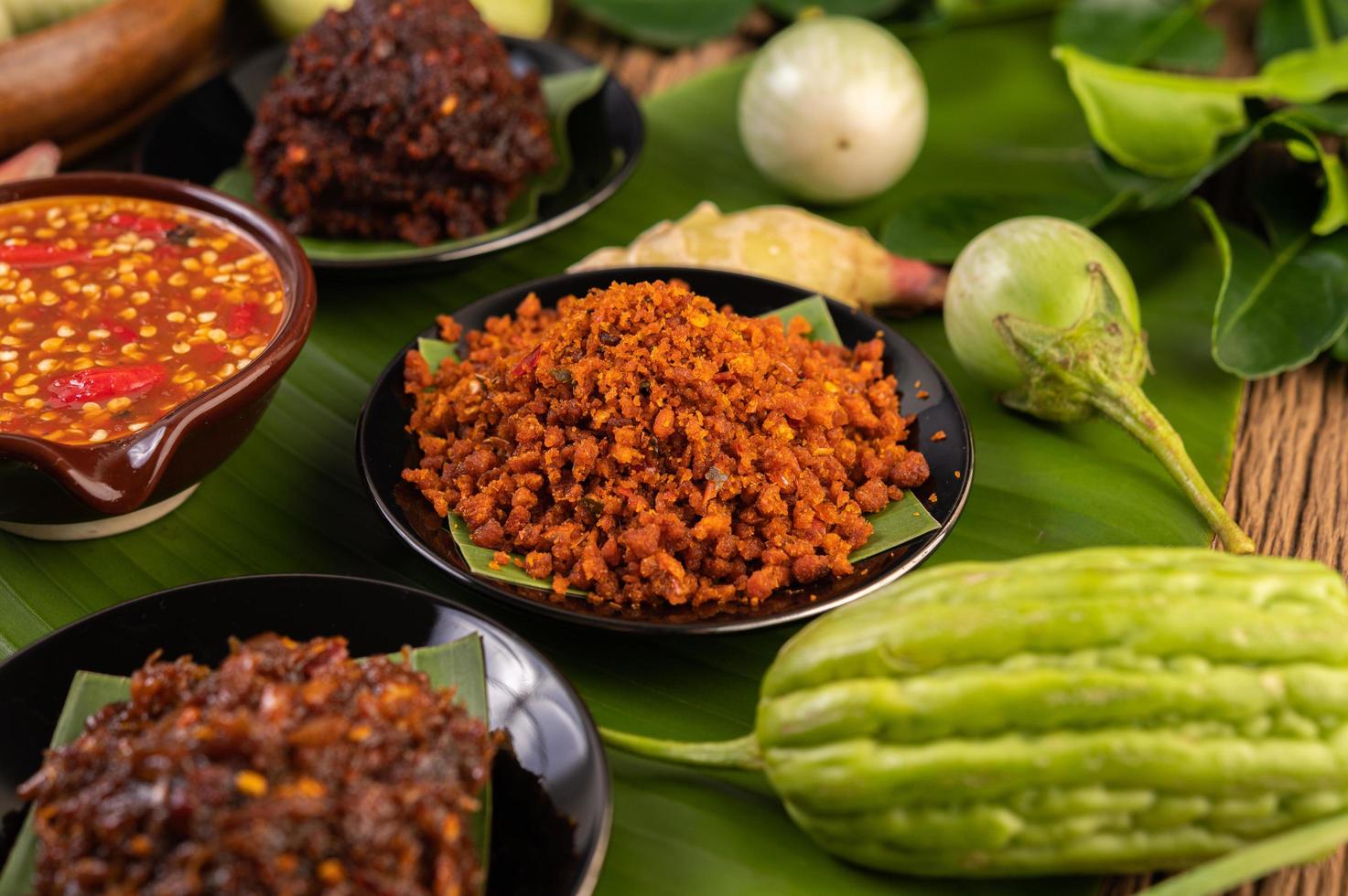 knusprige Schweinefleisch-Chili-Paste auf Bananenblättern mit Beilagen foto