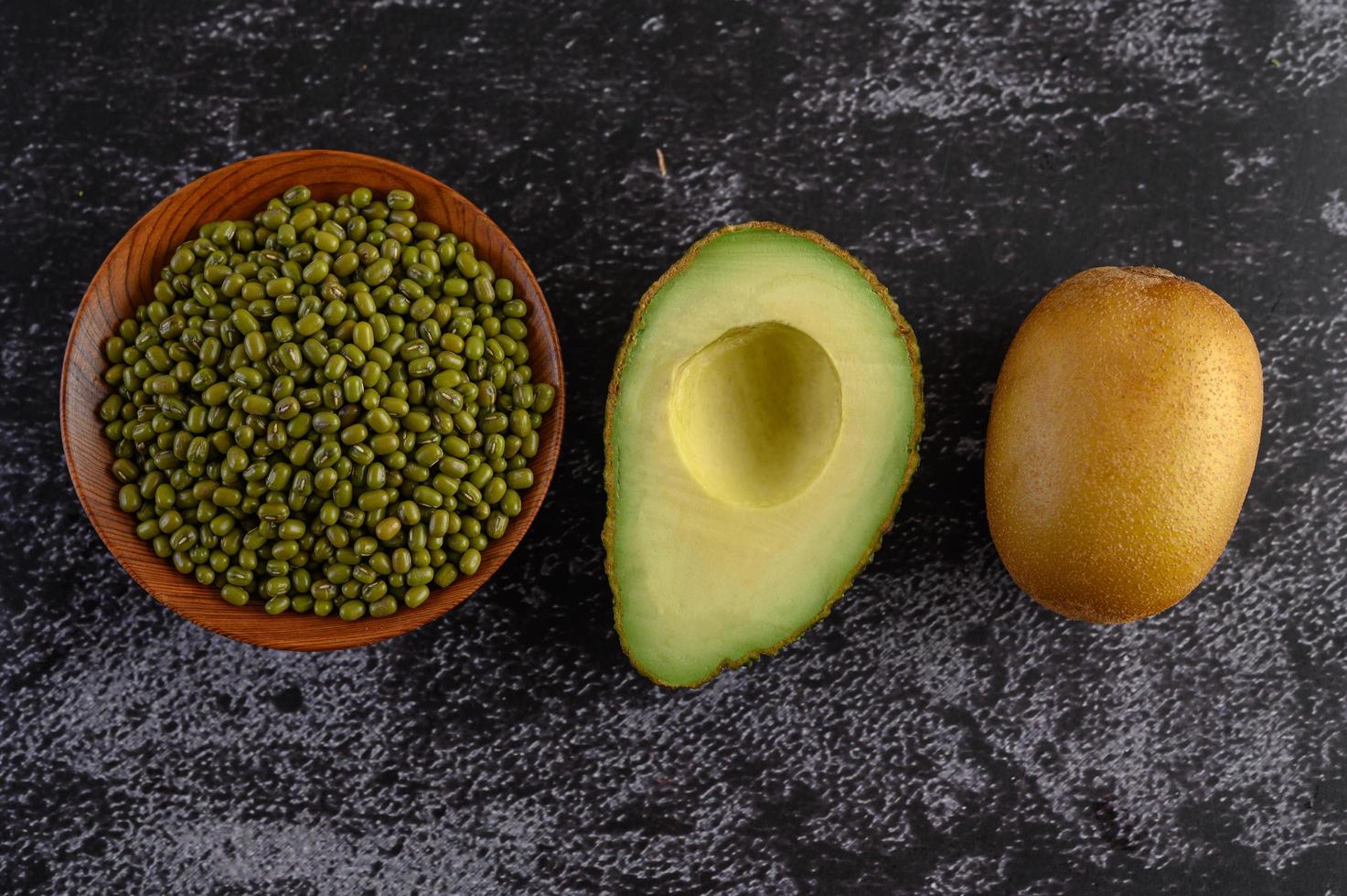 Mungobohne, Avocado und Kiwi auf einem schwarzen Zementbodenhintergrund foto