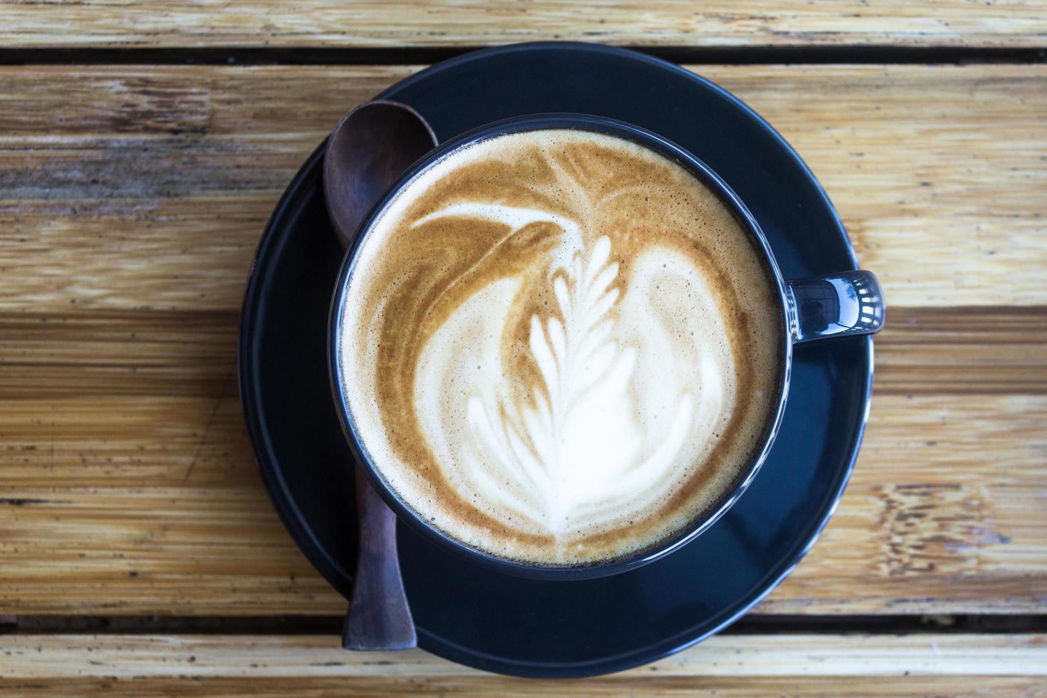 Kaffee mit Latte Art auf Holztisch foto