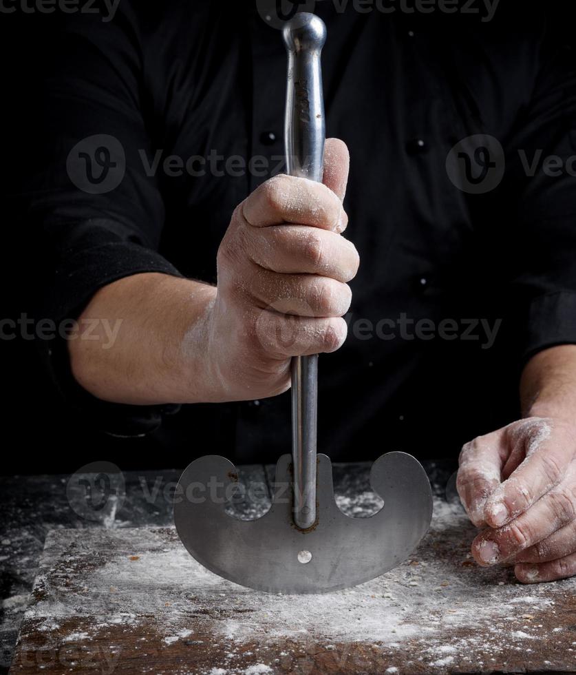Die rechte männliche Hand hält ein altes Küchenmesser aus Metall foto