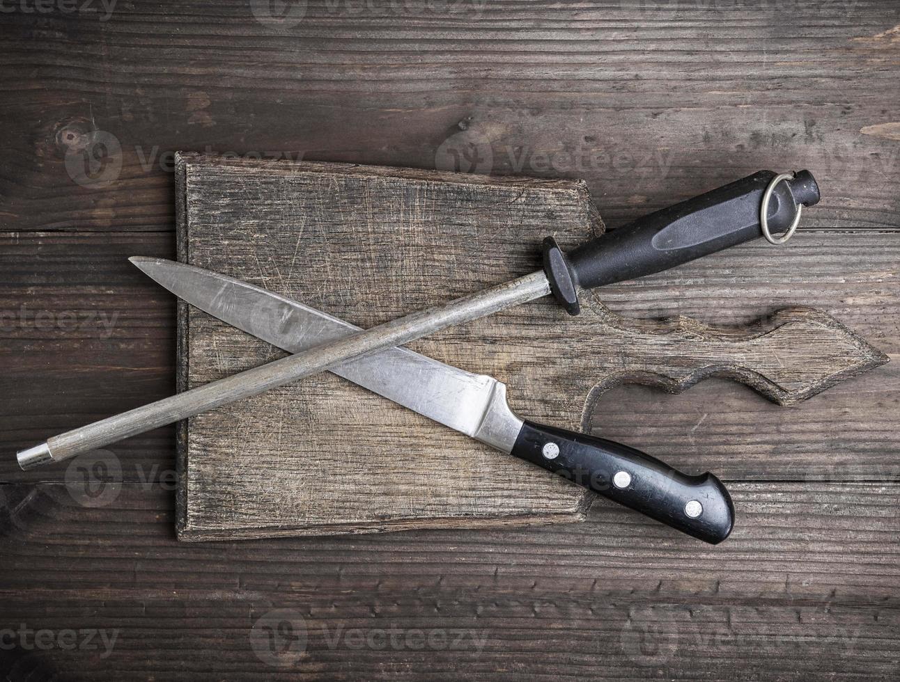altes braunes Holzschneidebrett und Messer mit Schärfen foto