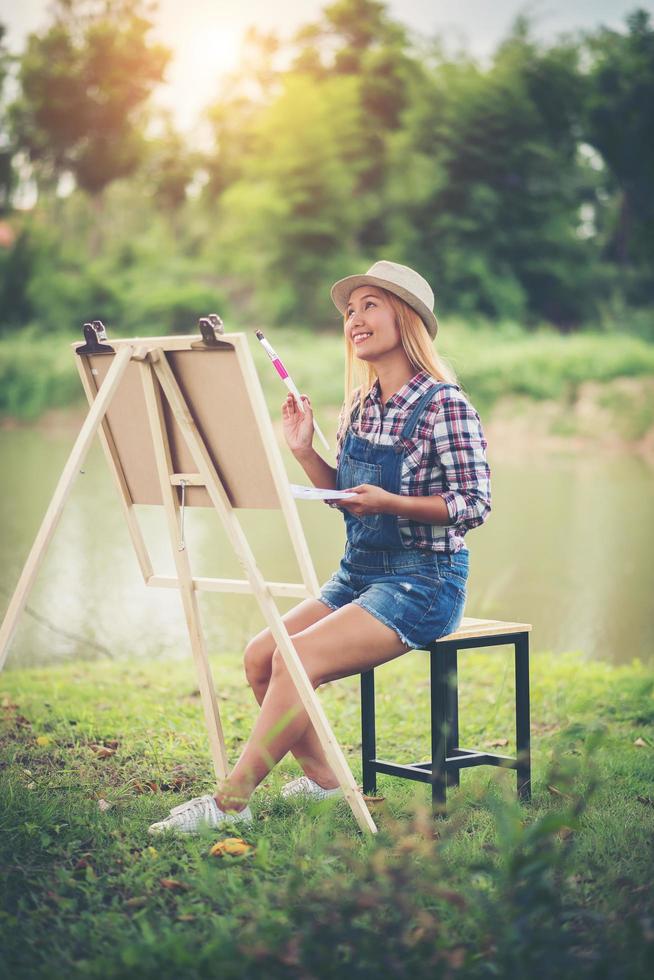 junge Frau zeichnet ein Bild im Park foto