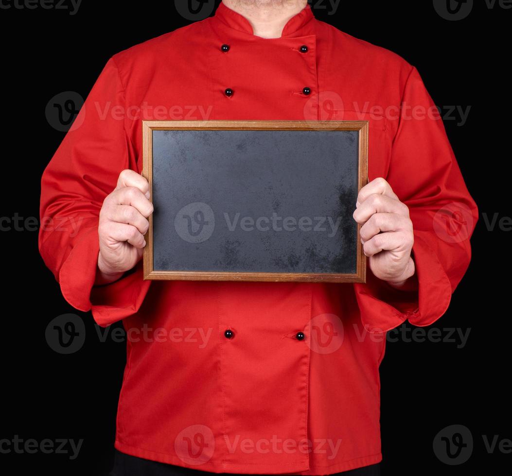 Koch in roter Uniform mit leerem Holzrahmen foto