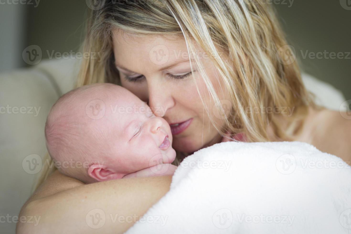 junge schöne mutter, die ihr kostbares neugeborenes mädchen hält foto