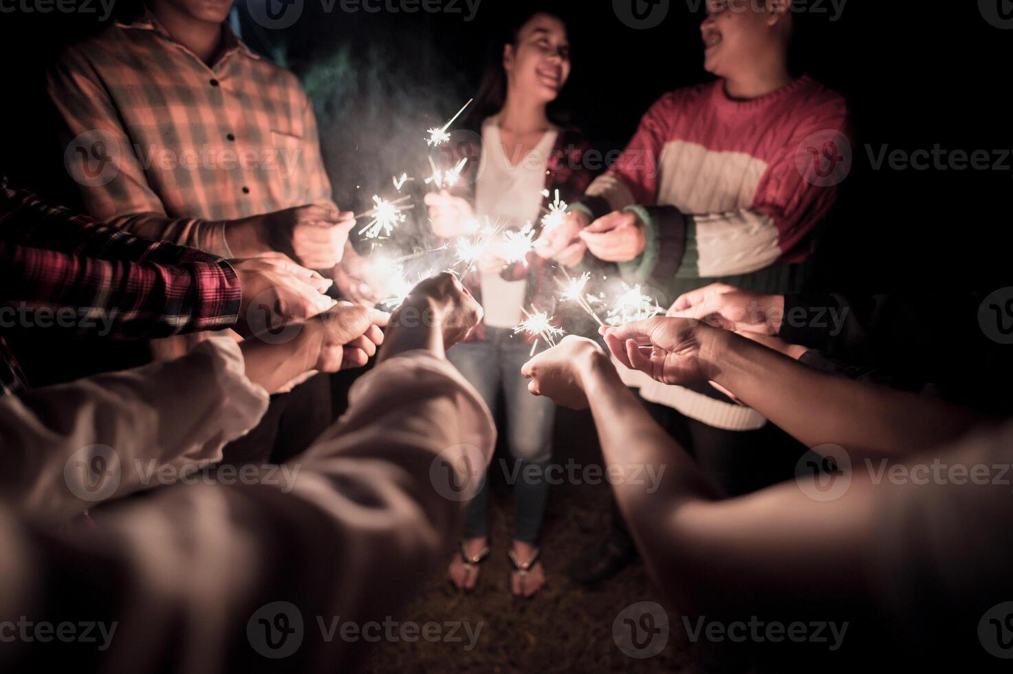 feuerwerk, das wunderkerze in den menschlichen händen in der partynacht des neuen jahres brennt foto