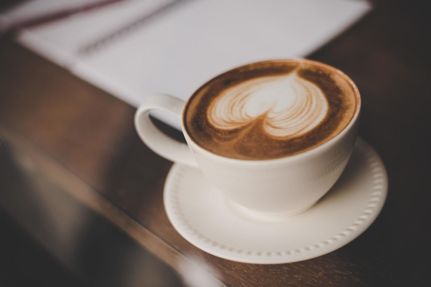 Vintage Ton Tasse heißen Kaffees mit Kunst in einer Herzform foto