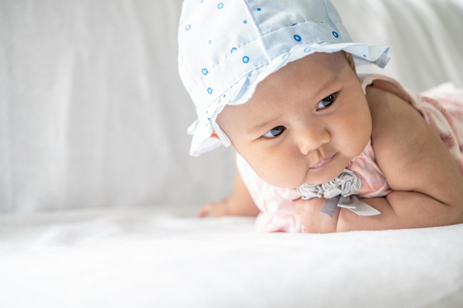 Das Baby liegt mit dem Kopf nach oben auf dem Bett foto