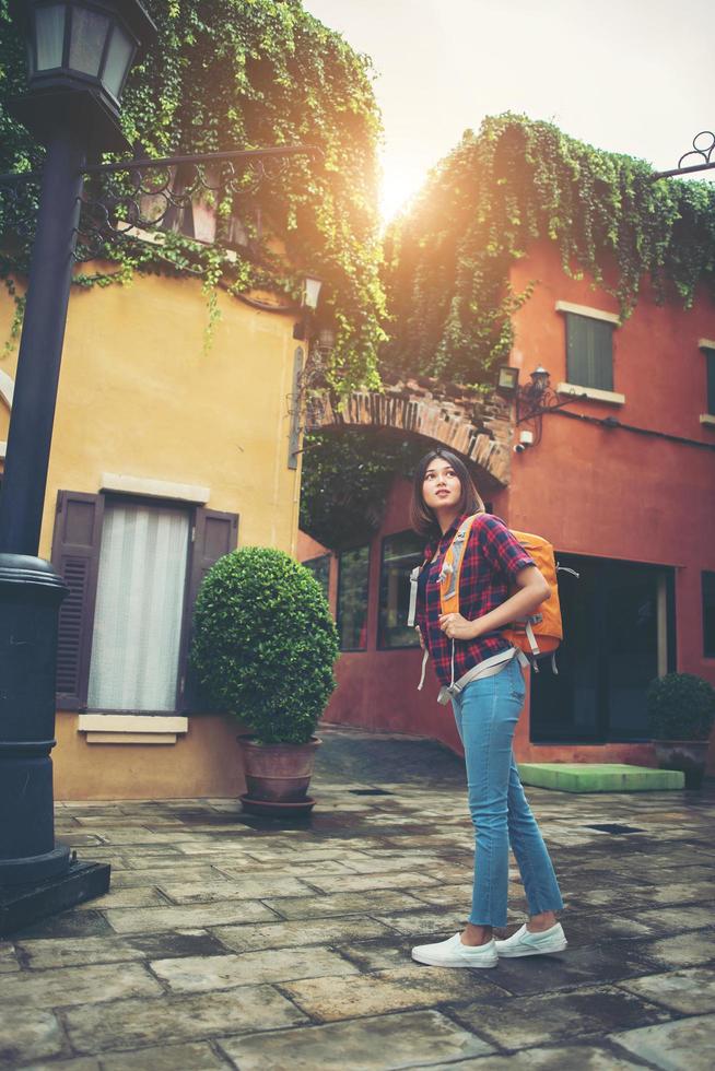 junge asiatische Frau, die um ein Stadtgebiet herumwandert foto