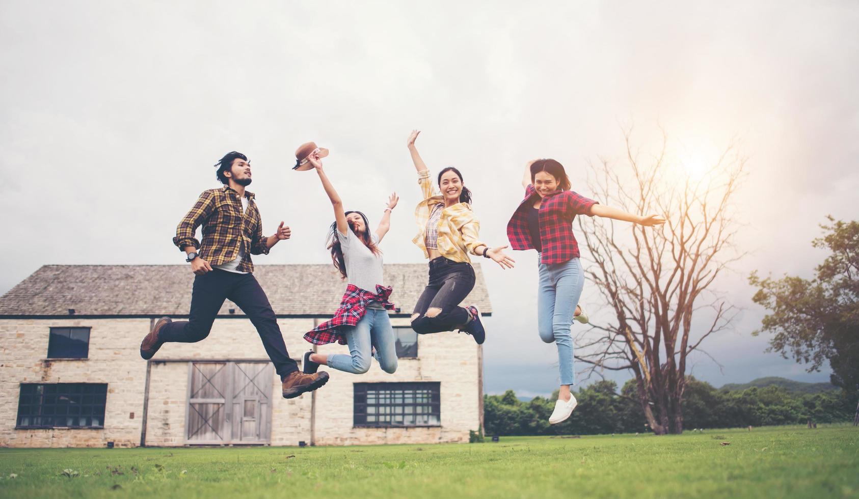glückliche Gruppe von jugendlichen Studenten, die zusammen in einen Park springen foto