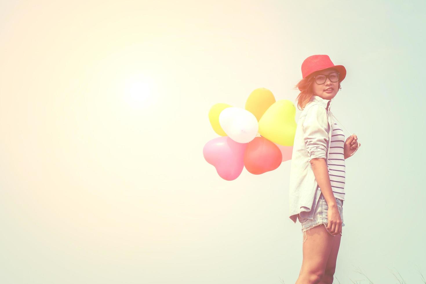 junge schöne Frau, die Luftballons in der frischen Luft hält foto