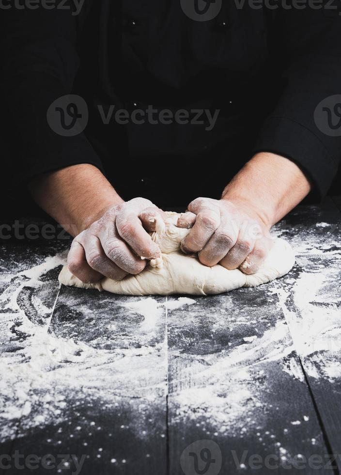 männliche Hände ersetzen weißen Weizenmehlteig foto