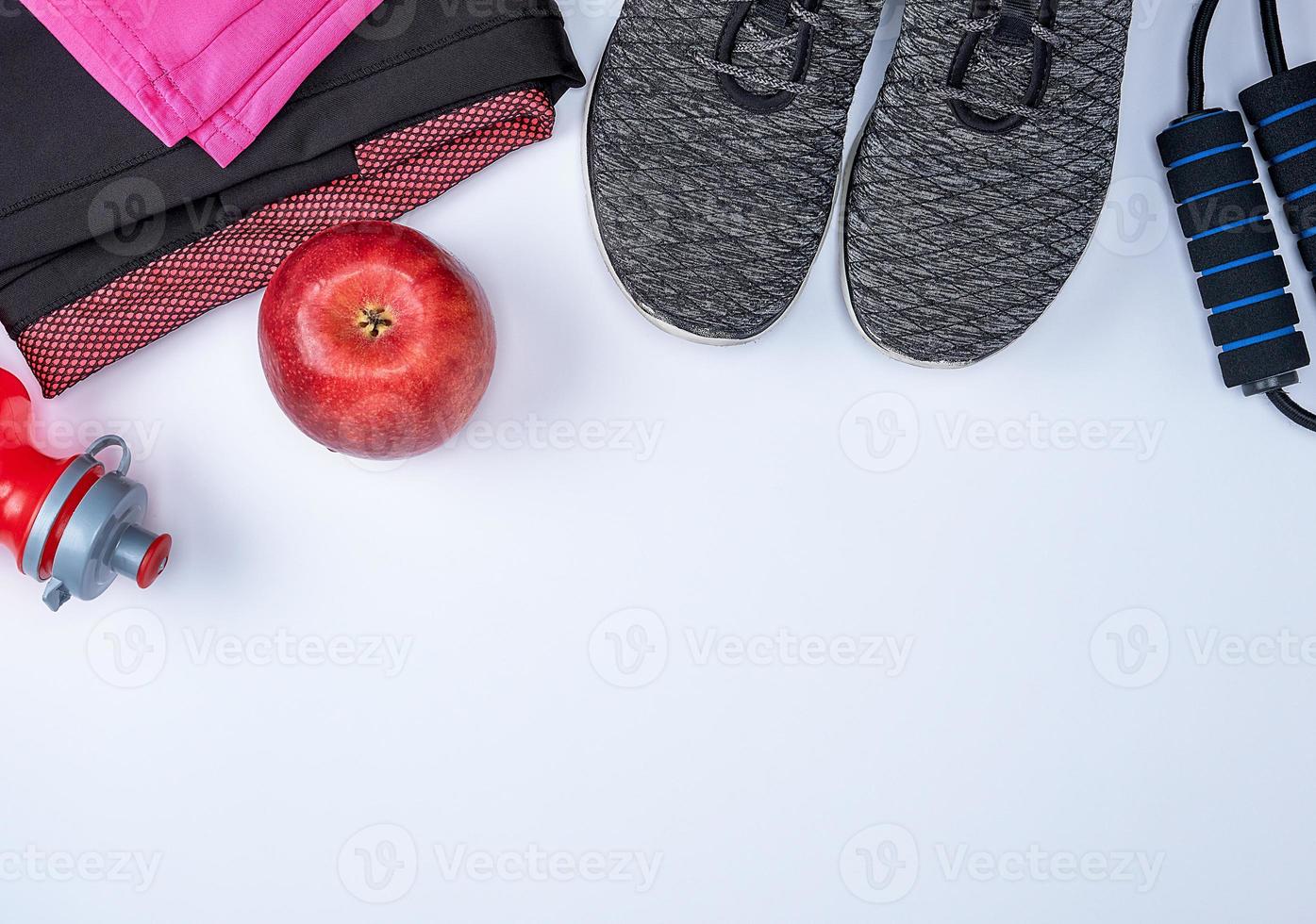 Schwarze Textilschuhe und andere Fitnessartikel auf weißem Hintergrund foto