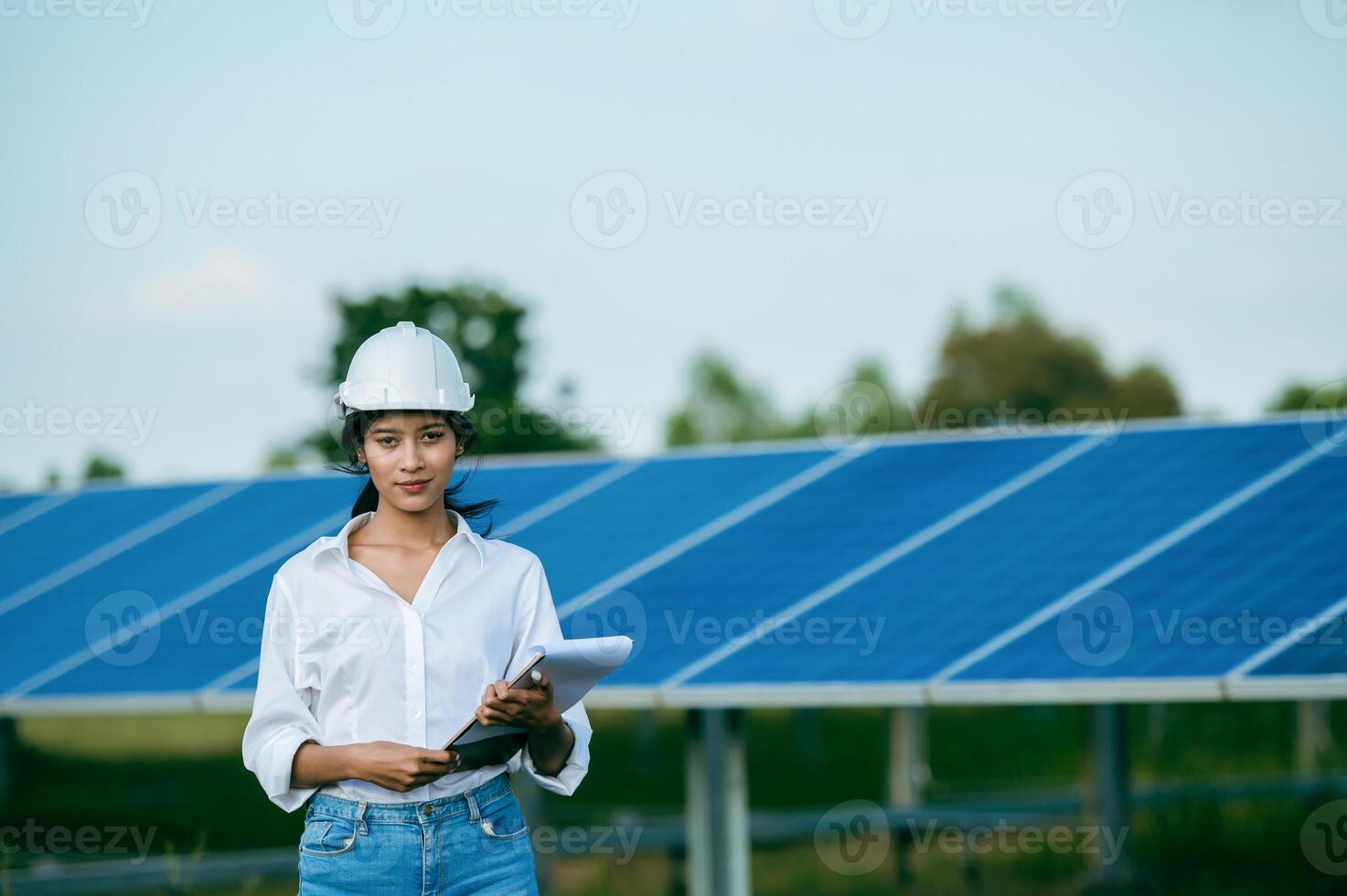 asiatische junge ingenieurin, die den betrieb im solarpark überprüft foto