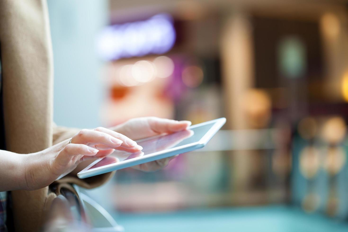 Frau mit Tablet-Computer im öffentlichen Raum foto