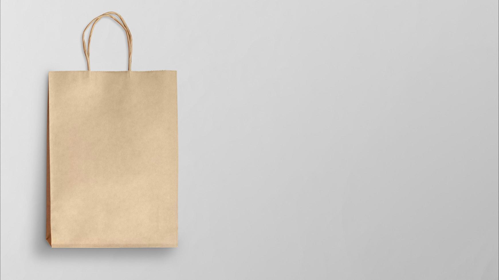 Einkaufstasche aus braunem Papier auf grauem Hintergrund foto