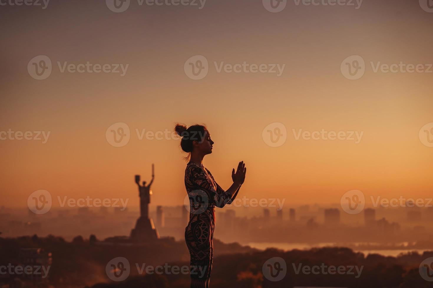 Frau beim Yoga auf dem Dach eines Wolkenkratzers in der Großstadt. foto