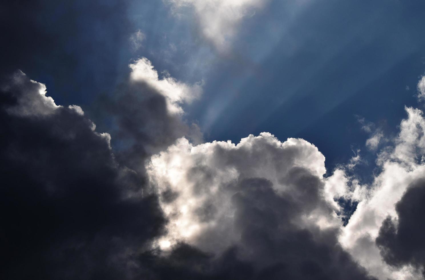 Wolken von Sonnenlichtstrahlen mit dunkelblauem Himmel hinterleuchtet foto