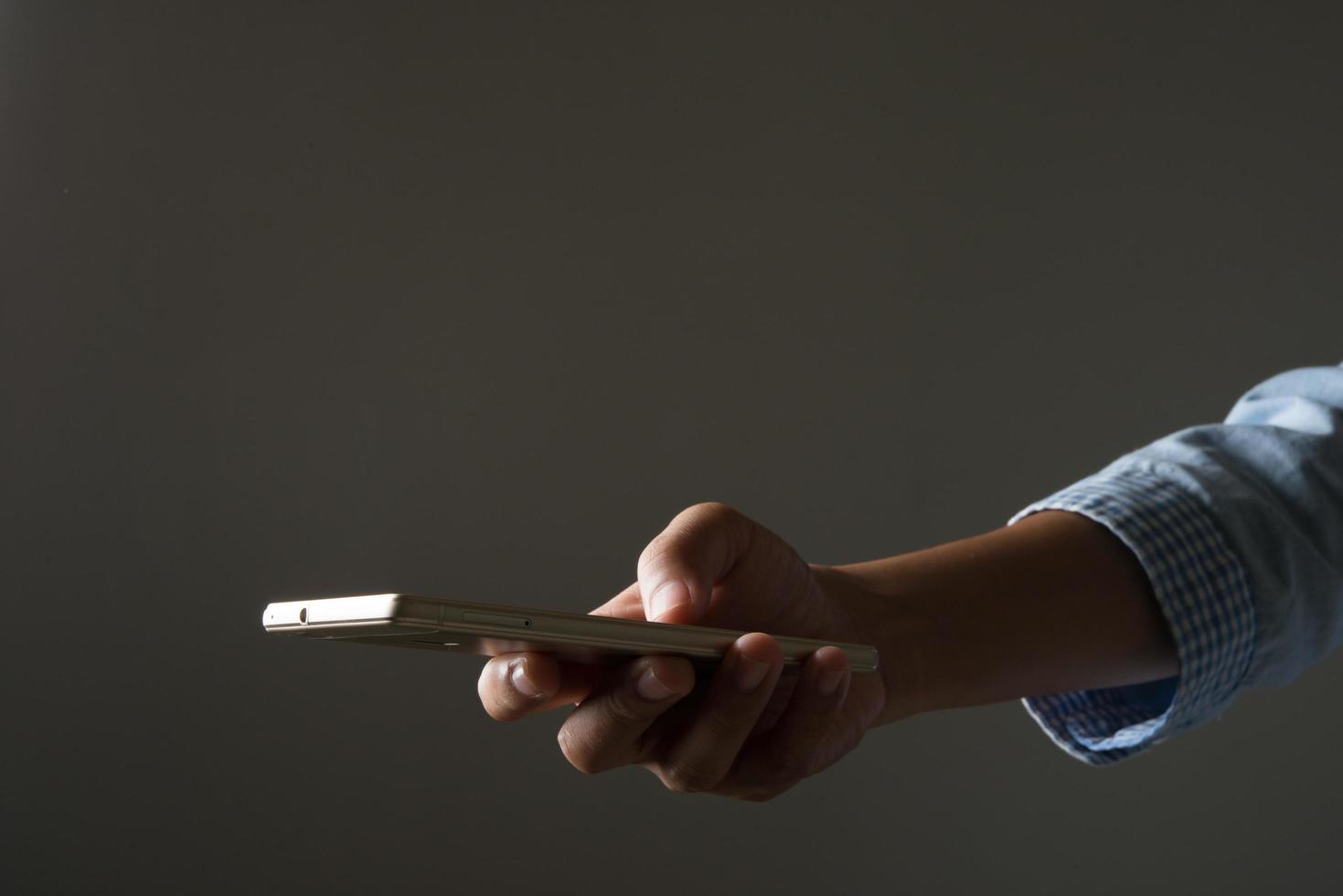 Porträt einer Frau, die Smartphone gegen Hintergrund hält foto