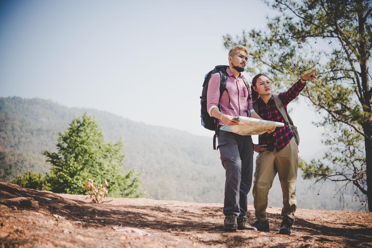 junges Touristenpaar, das zu einem Berg wandert foto