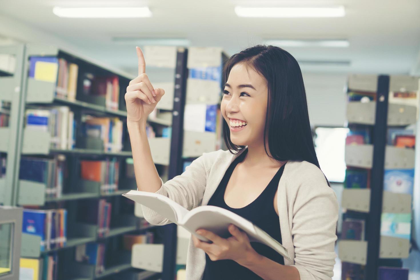 Porträt eines Studenten, der eine gute Idee in der Bibliothek hat foto