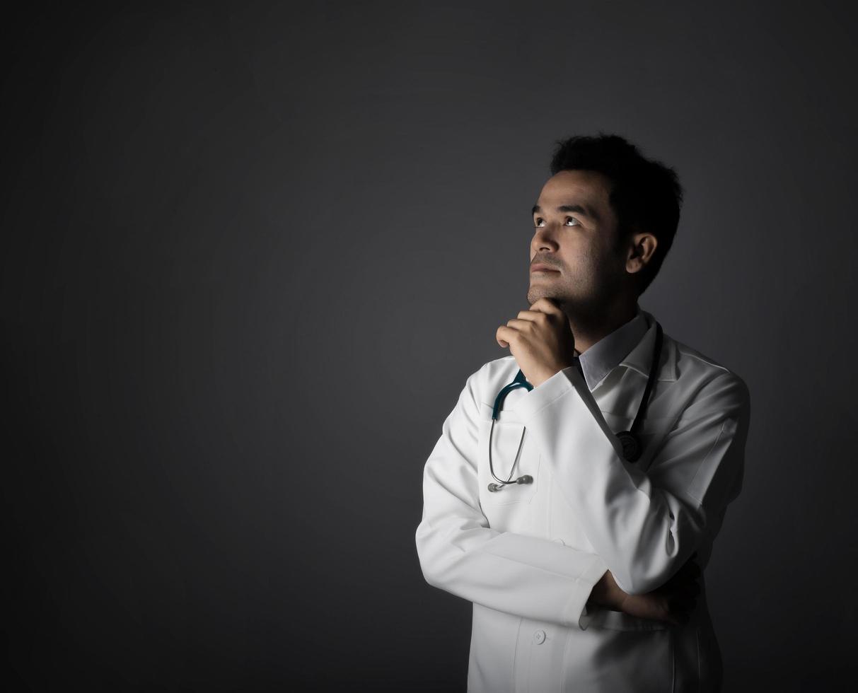 Arzt mit Stethoskop lokalisiert auf grauem Hintergrund foto
