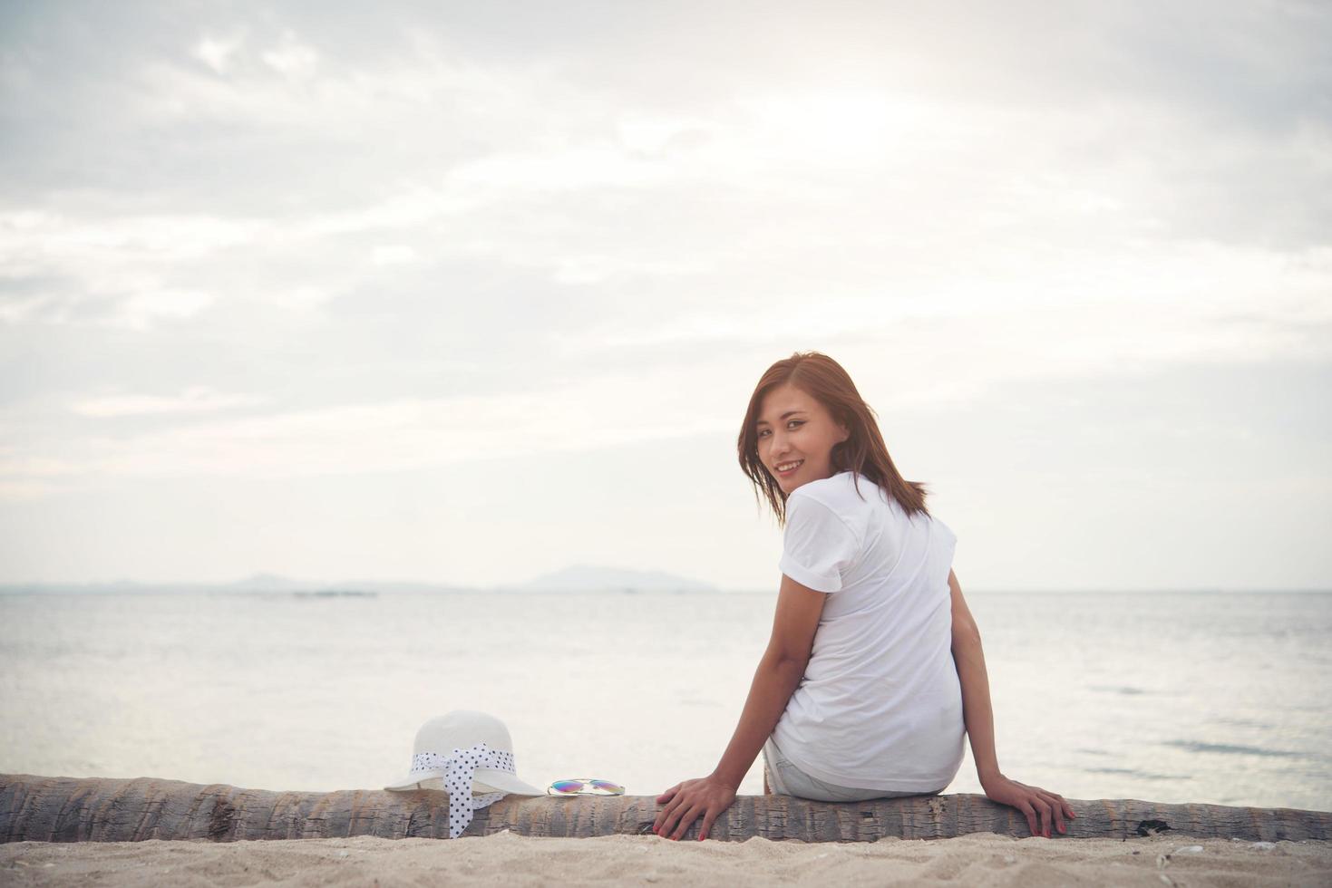 junge schöne Frau, die am Strand entspannt foto