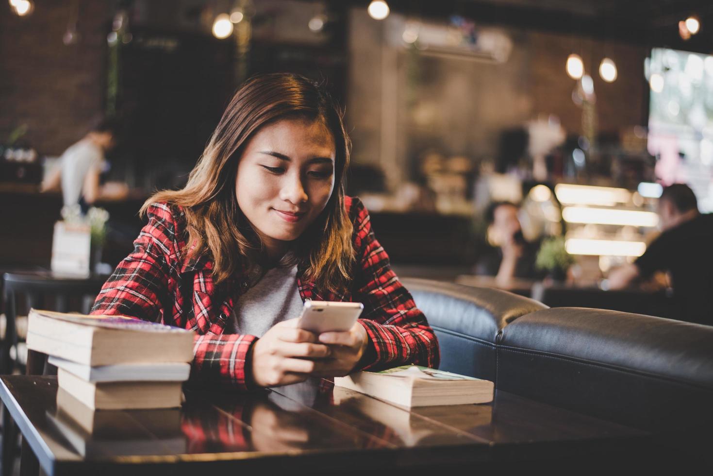 Hipster Teenager sitzt und genießt ein Buch in einem Café foto