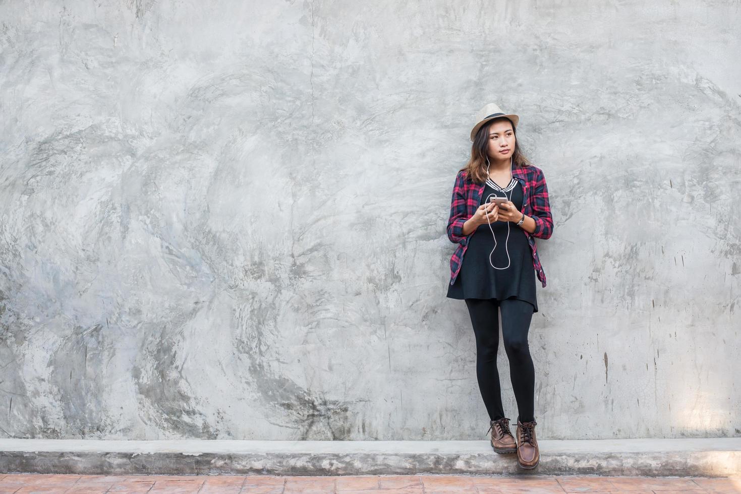 Porträt einer jungen Hipsterfrau, die Musik mit Smartphone hört foto