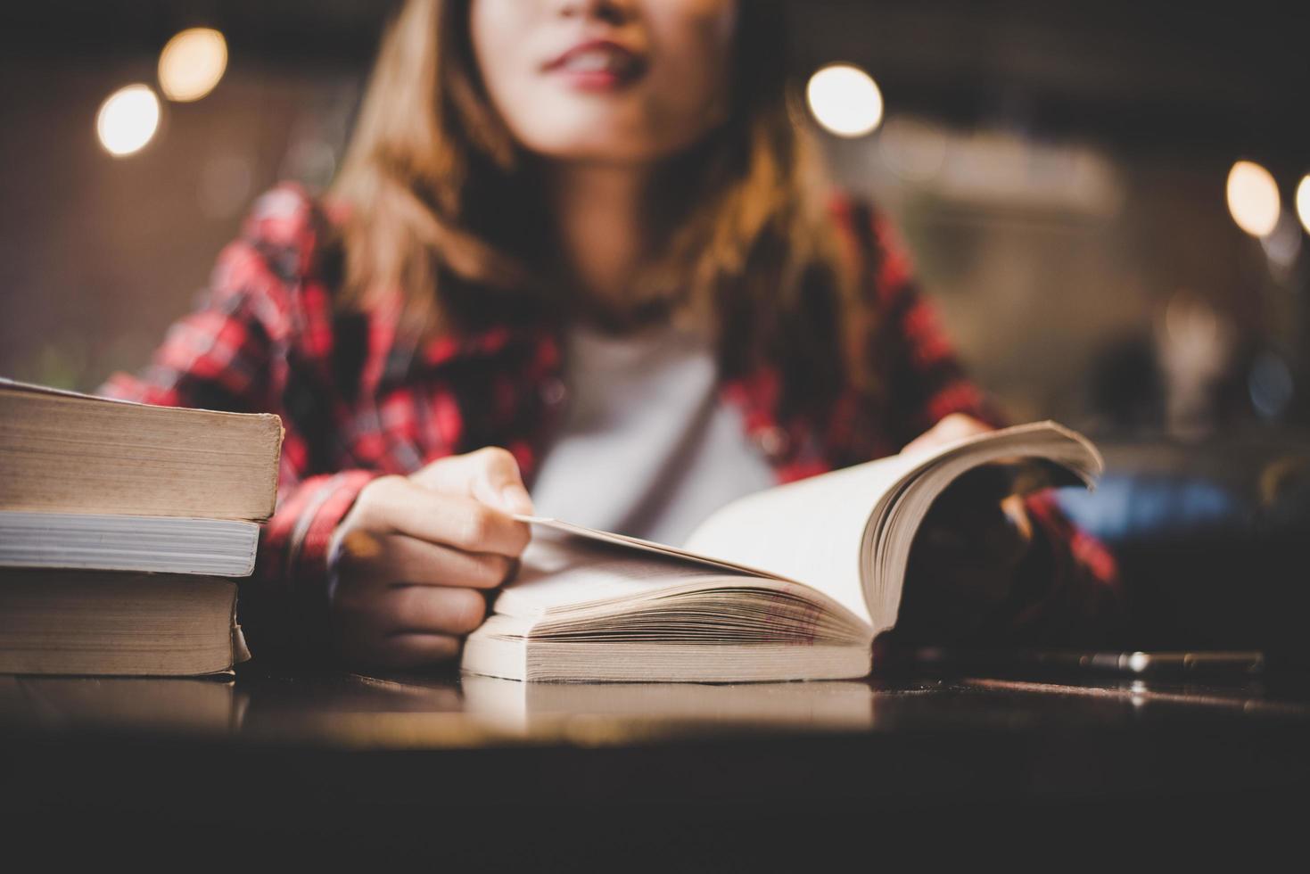 Hipster Teenager sitzt und genießt ein Buch in einem Café foto