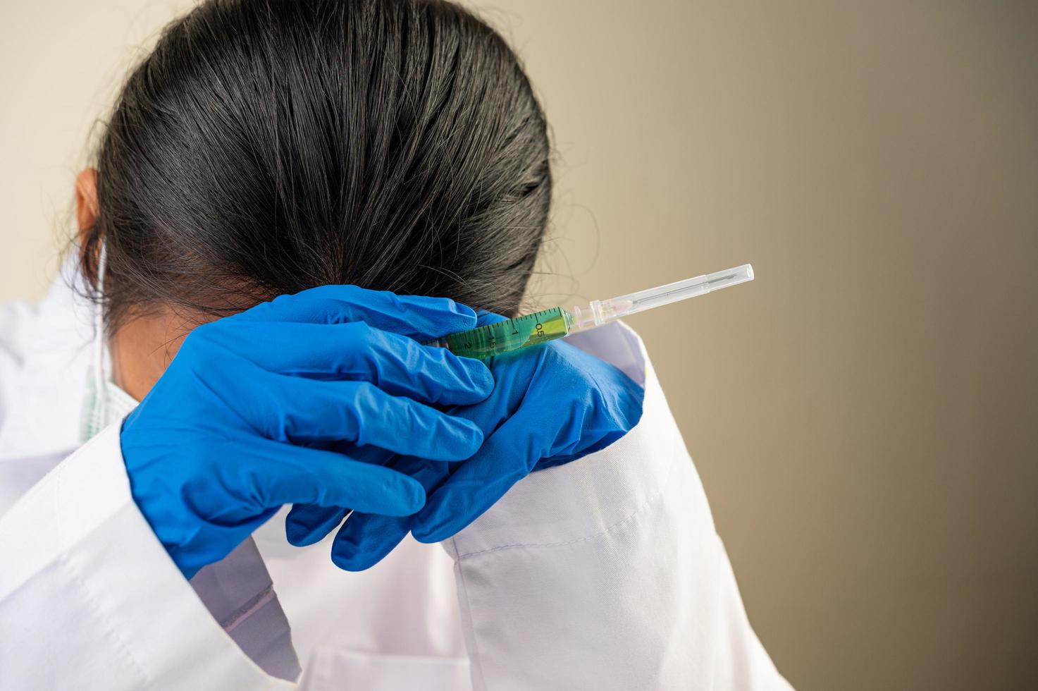 Wissenschaftler am Tisch mit Impfstoffen und Drogen foto