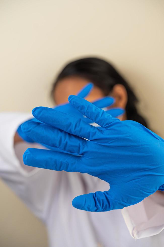 Wissenschaftler mit blauem Handschuh macht Hände bei inakzeptablem Impfstoff foto