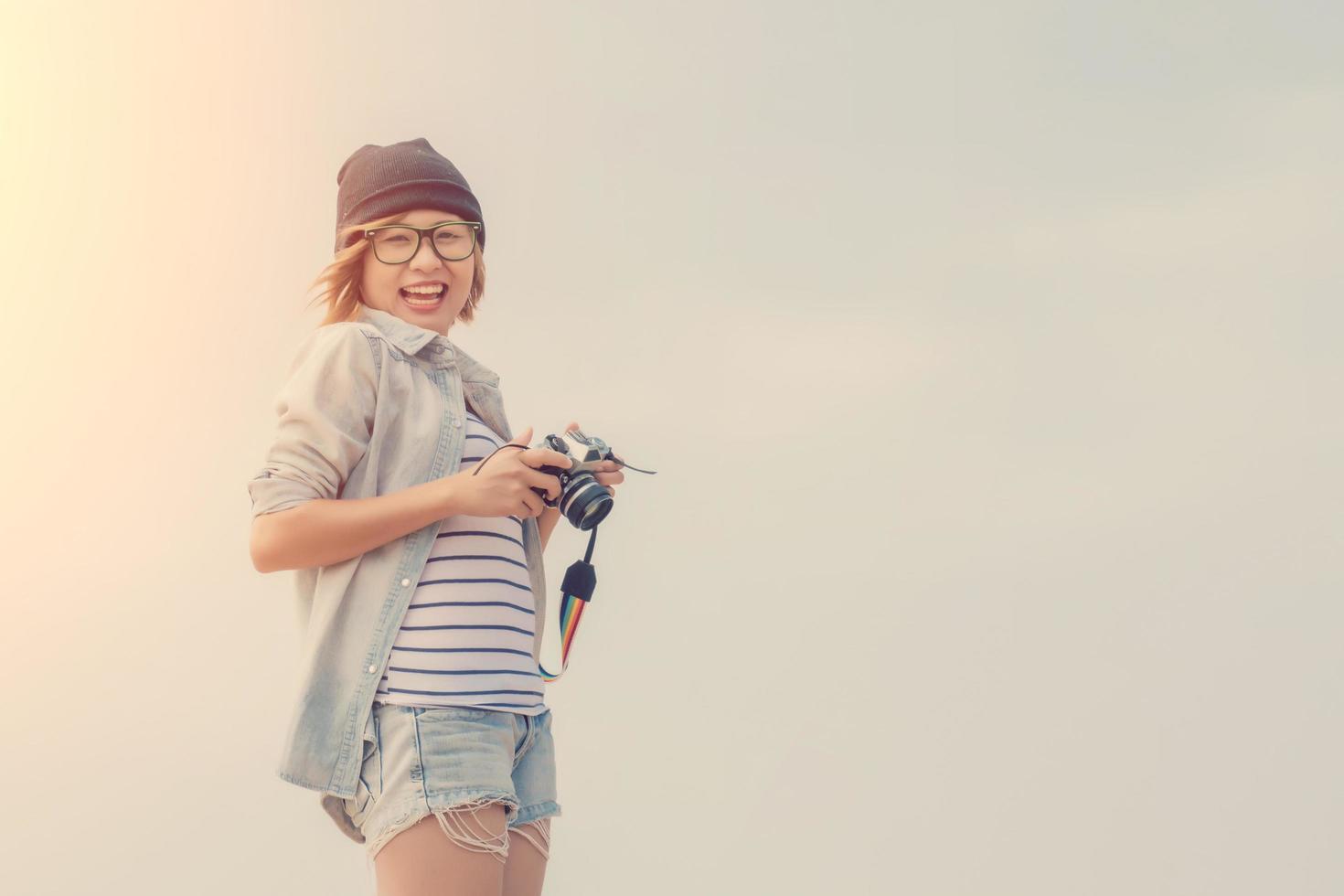 schöne junge Frau Fotografin hält Retro-Kamera foto