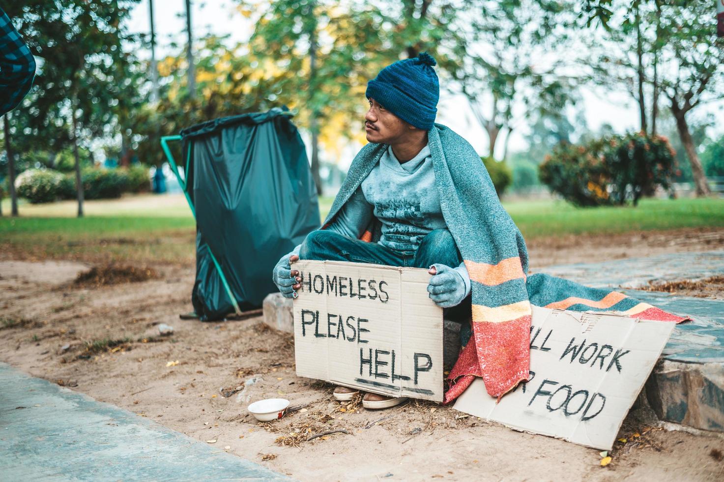 Bettler in Stoff gewickelt auf der Straße Geld annehmen foto