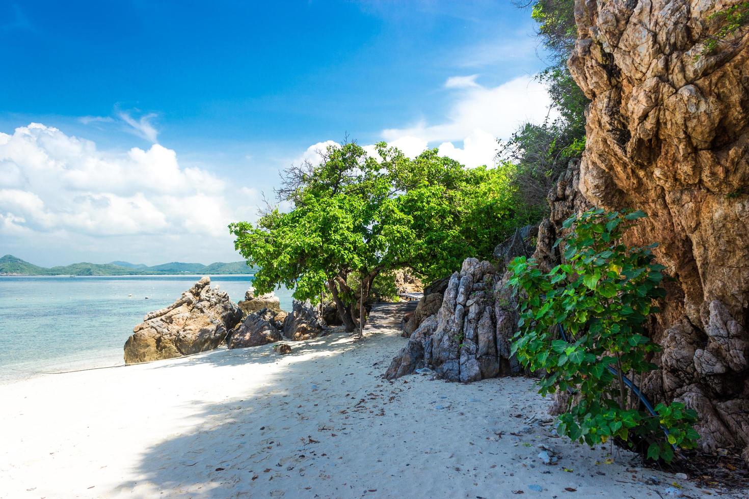 tropischer Inselfelsen am Strand mit bewölktem blauem Himmel foto