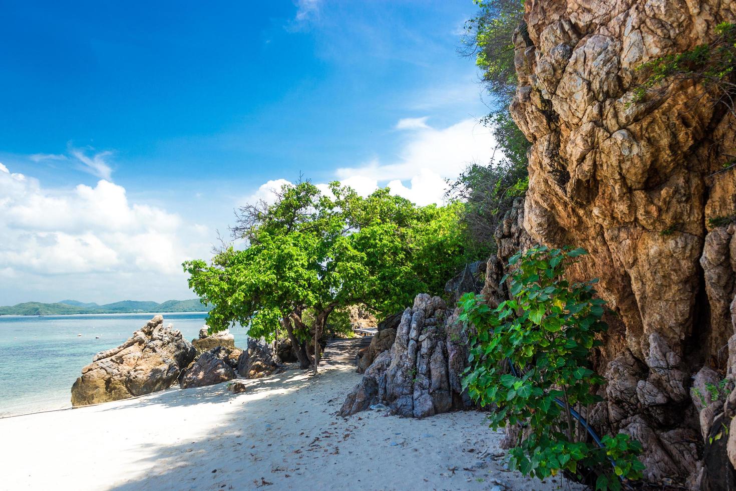 tropischer Inselfelsen am Strand mit klarem blaugrünem Wasser foto
