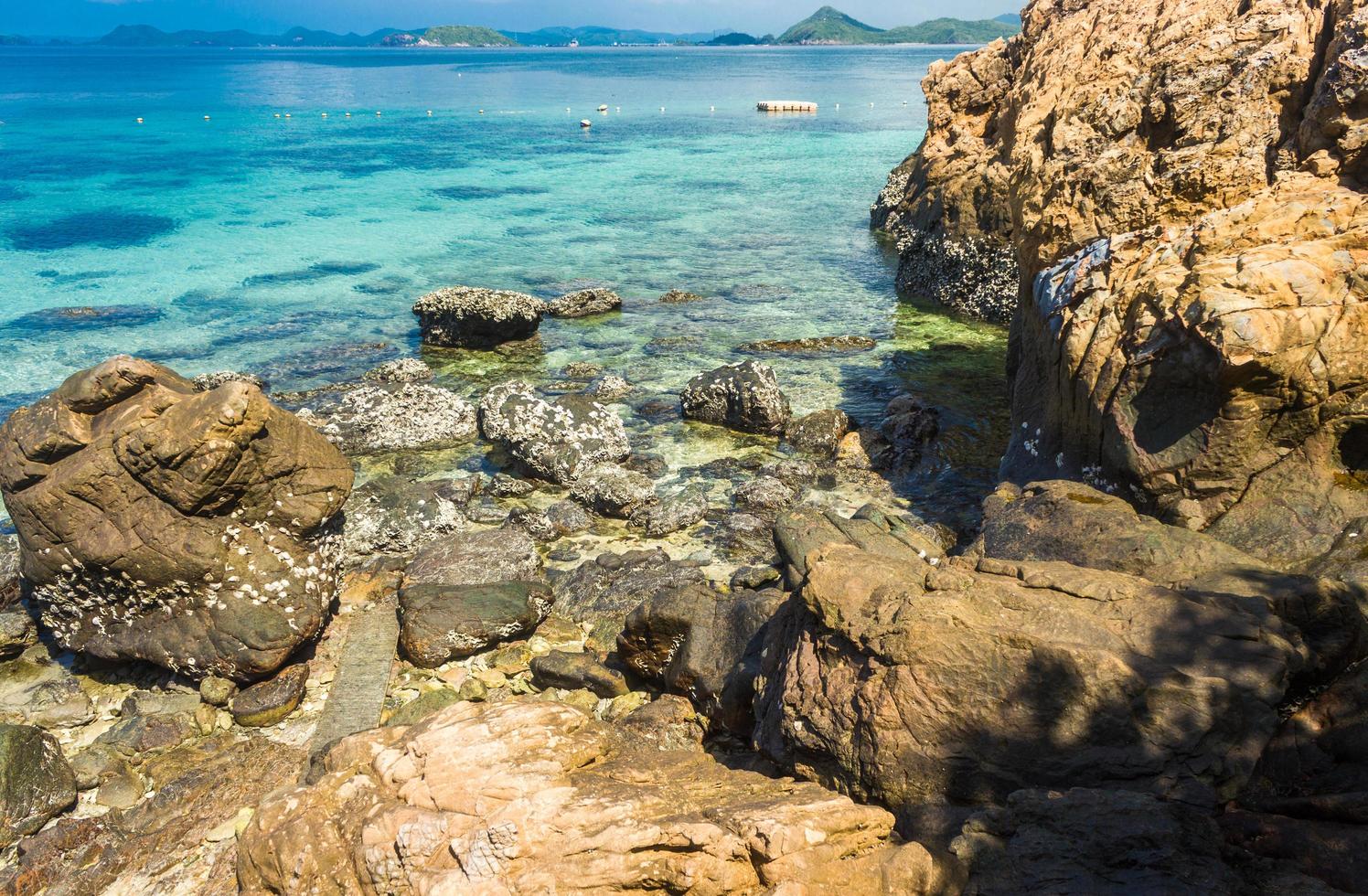 tropischer Inselfelsen am Strand mit bewölktem blauem Himmel foto