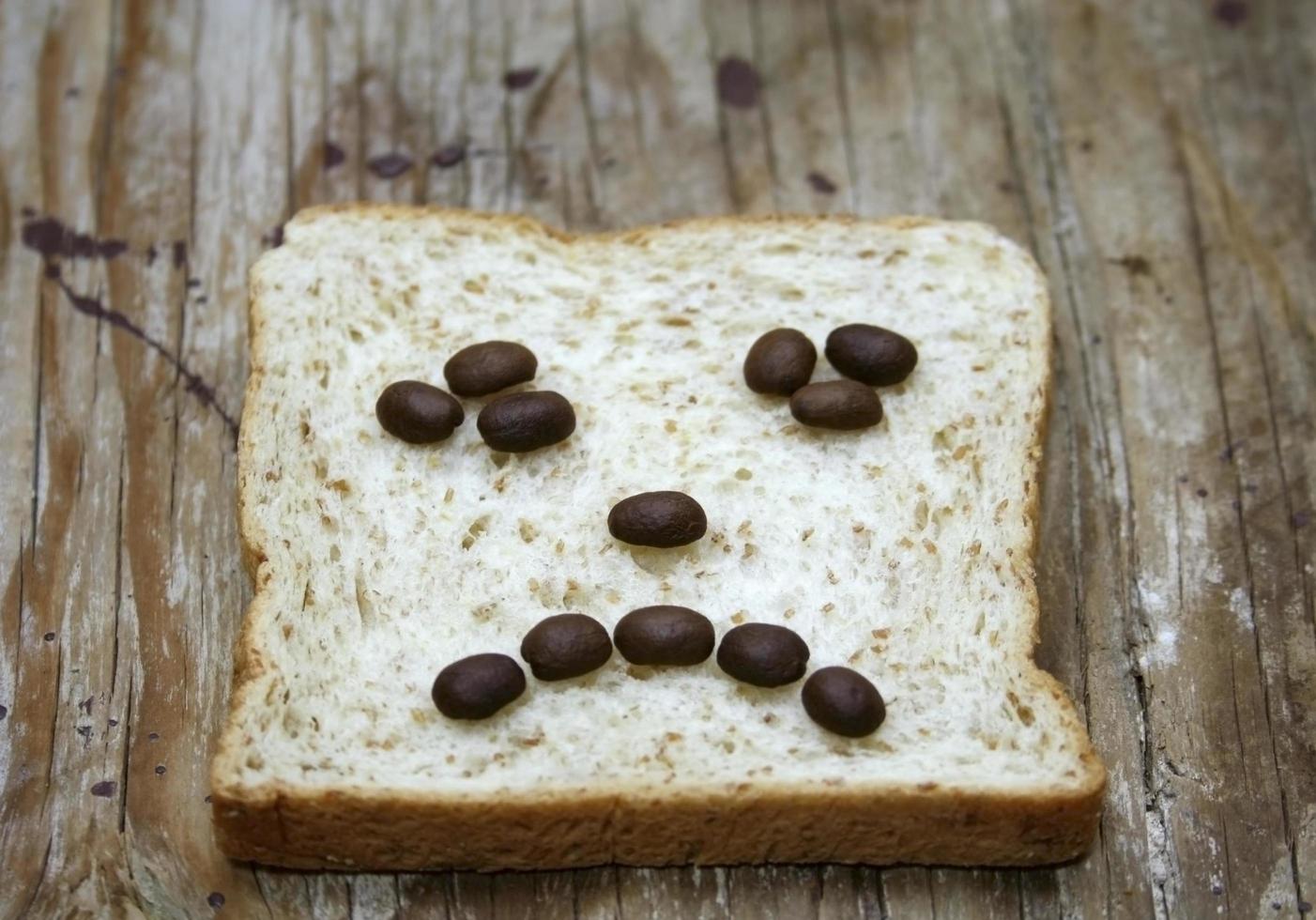 stirnrunzelndes Gesicht aus Kaffee und Brot foto